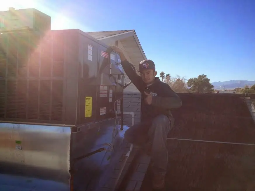 HVAC technician performing Air Duct Cleaning on a rooftop unit in Moss Bluff